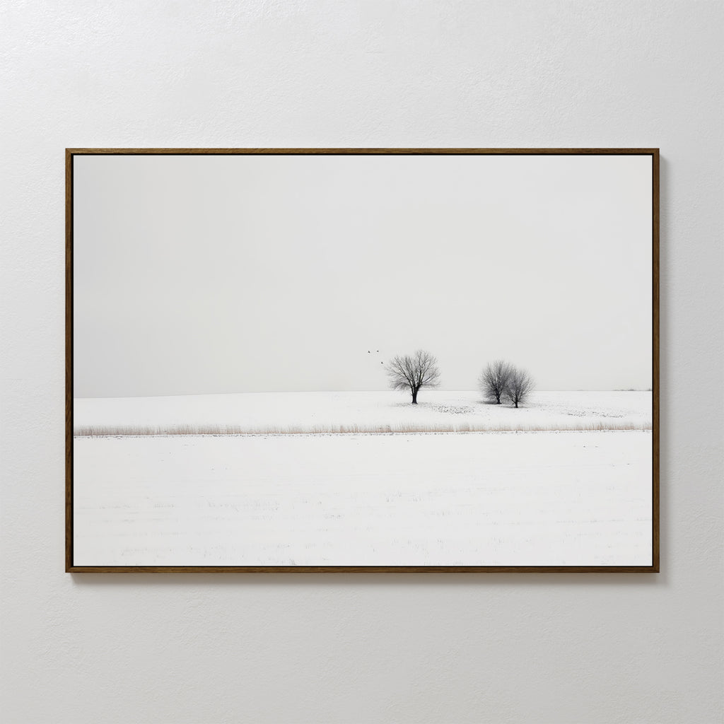 Winter Silence Canvas Art features a minimalist photograph of two bare trees in a snowy landscape beneath a pale sky—an elegant choice for winter wall decor.
