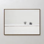 Winter Silence Canvas Art features a minimalist photograph of two bare trees in a snowy landscape beneath a pale sky—an elegant choice for winter wall decor.