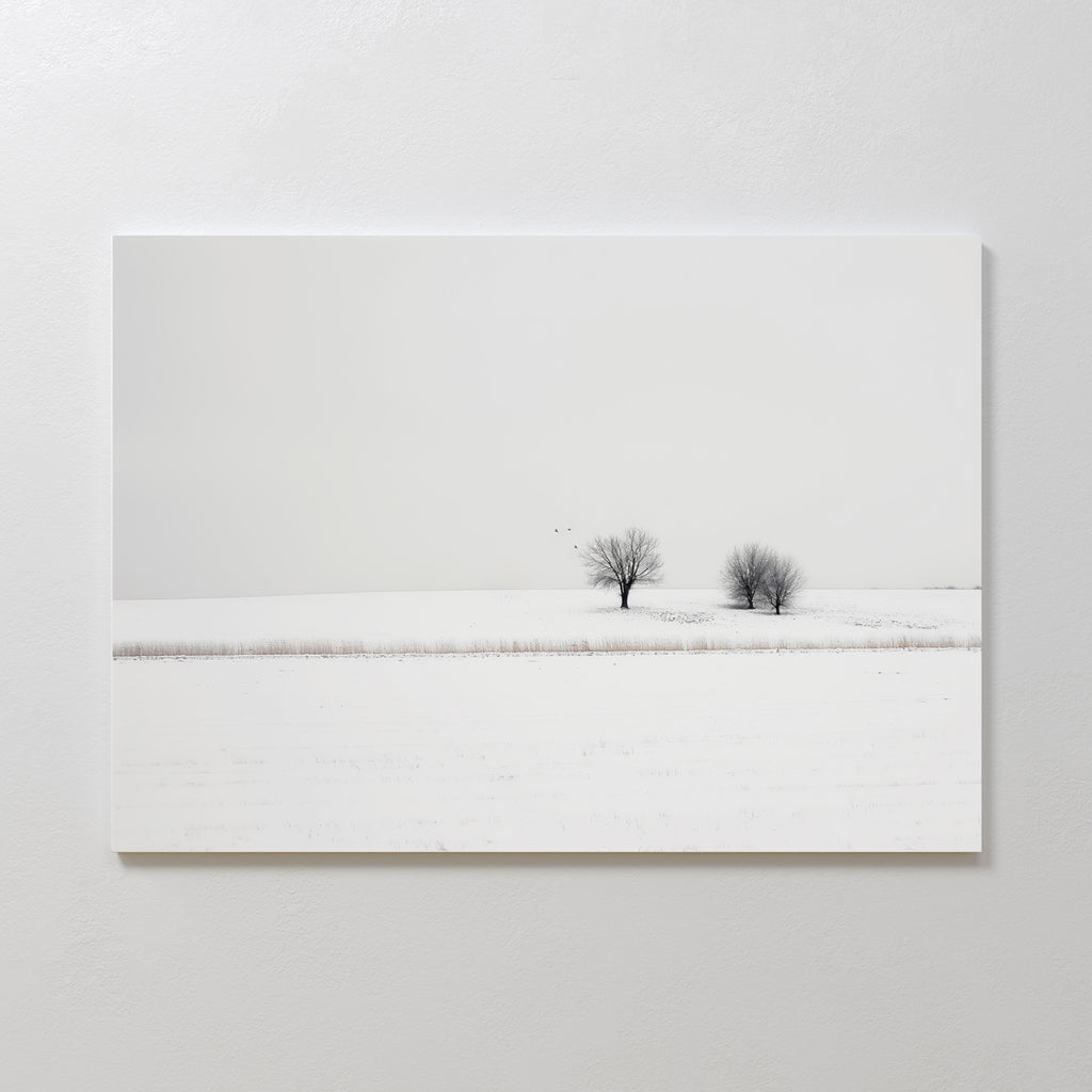 Winter Silence Canvas Art features a minimalist snow-covered landscape with two bare trees under a pale sky and three birds flying above—ideal for serene winter decor or elegant minimalist wall art.
