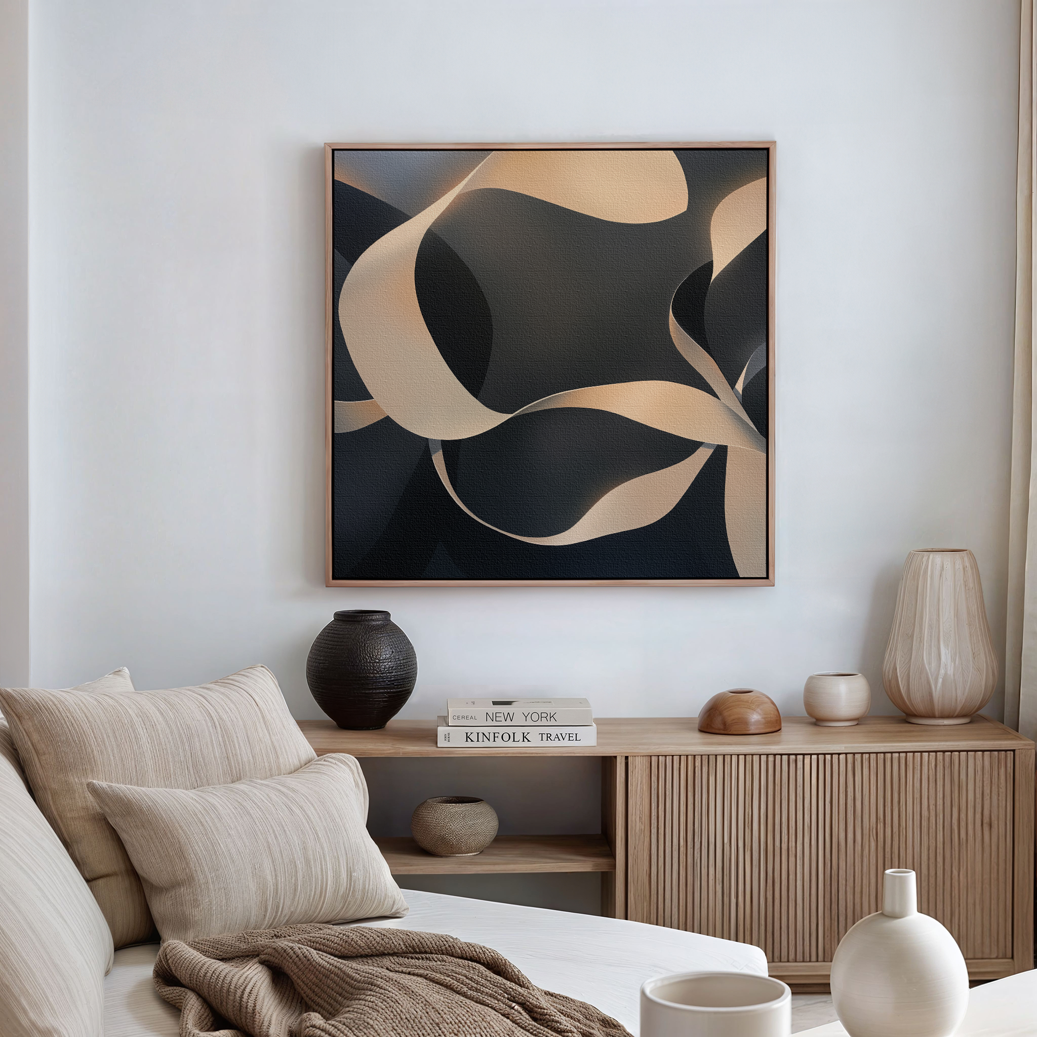 A modern living room with neutral tones showcases modern elegance, featuring a wooden sideboard, ceramic vases, books, and the Quiet Division Abstract Canvas Art with flowing beige and dark shapes above a beige sofa with pillows.