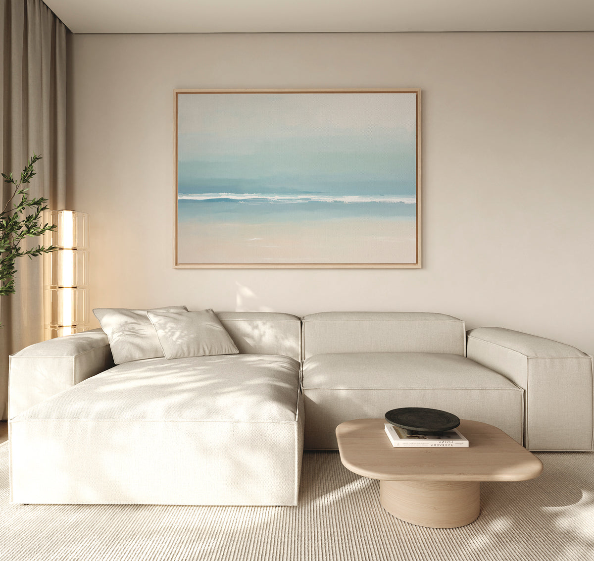 A modern living room featuring a light beige sectional, wooden coffee table, minimalist black bowl, tall plant, and the Airy Shore Canvas Art - Horizontal for a calm seaside vibe. Neutral tones and soft natural light complete the look.