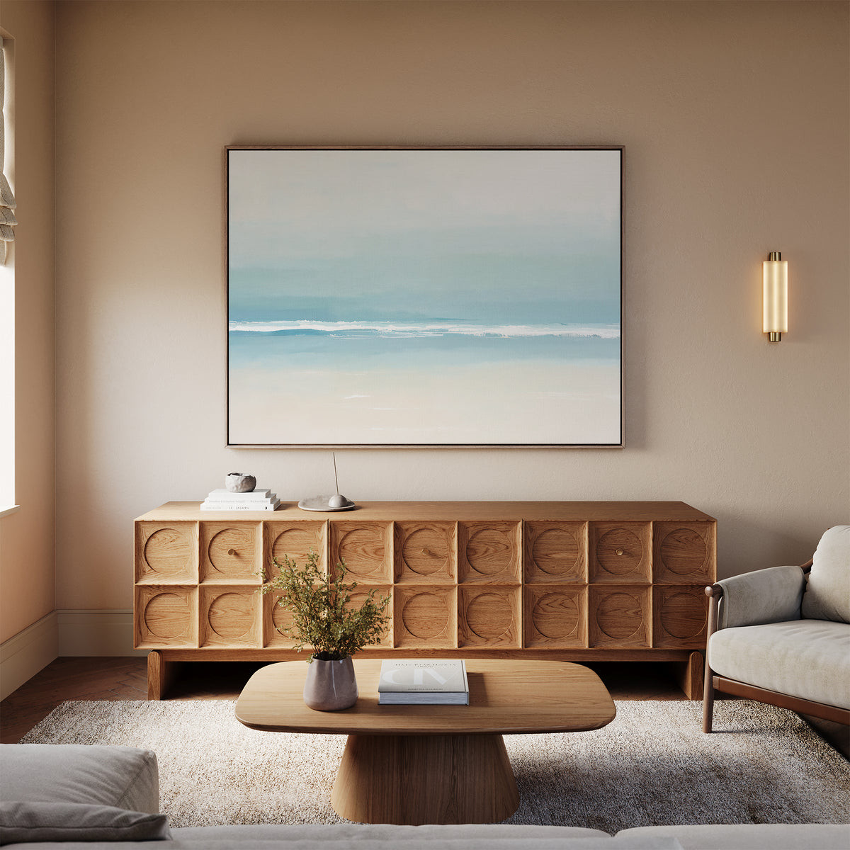 A modern living room features a textured wooden sideboard with Airy Shore Canvas Art - Horizontal above it, a low coffee table with a vase of flowers, light sofa, neutral walls, and soft natural light for a calming seaside atmosphere.