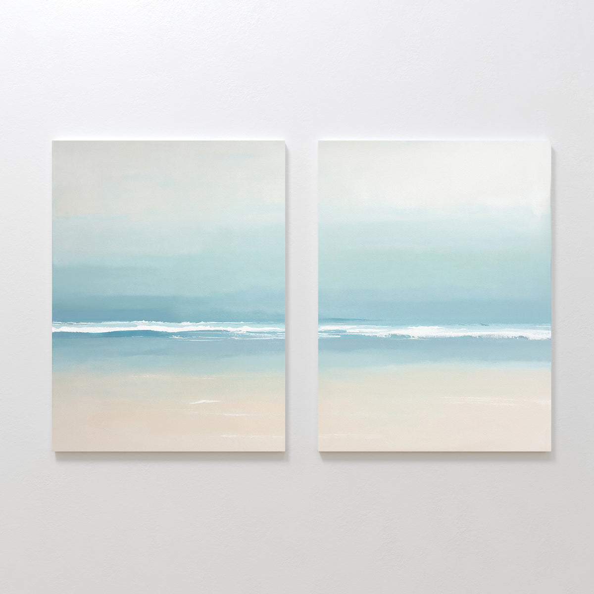 Airy Shore - Set Of 2 features two minimalist prints with soft blue and beige tones, capturing a calm ocean horizon and gentle waves beneath a pale sky for a serene coastal vibe.