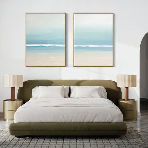 A modern bedroom with a green upholstered bed, white bedding, beige nightstands, and the Airy Shore - Set Of 2 coastal prints above the bed. A neutral palette and patterned rug create a calm, serene atmosphere.