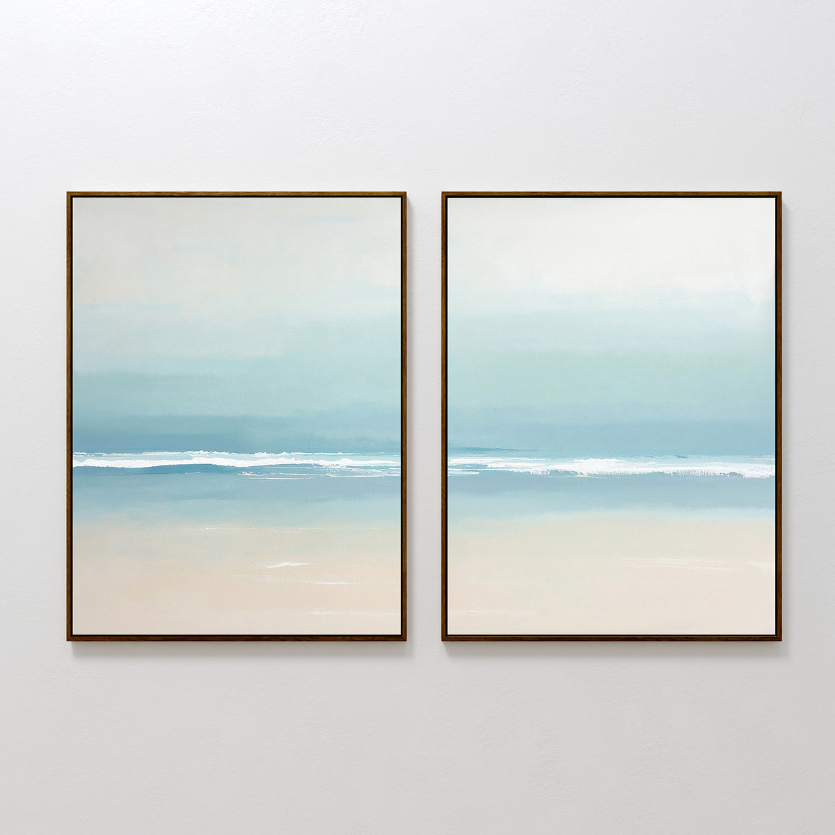 The Airy Shore - Set Of 2 features framed coastal wall art with serene waves in pastel blues, beiges, and whites, creating a peaceful beach vibe; display both pieces side by side on a white wall.