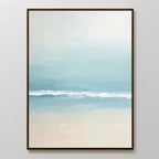 Airy Shore Canvas Art - Vertical features a minimalist seascape in soft blue, white, and sandy beige tones with gentle waves, framed in a slim dark frame. This coastal print adds tranquil seaside vibes to Nordic Park wall art decor.