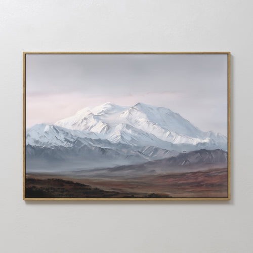 The Alpine Majesty Canvas Art - Horizontal features a snow-capped peak under clouds, misty mountain ranges, and a balanced palette over a barren foreground, displayed on a white wall.