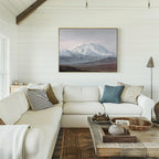A bright, cozy living room with a white sectional sofa, assorted pillows, a rustic wooden coffee table, and the Alpine Majesty Canvas Art - Horizontal on a shiplap wall. The balanced mountain palette and natural light create an inviting Nordic Park vibe.