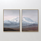 The "Alpine Majesty - Set of 2" features framed wall art of snowy mountain peaks under a pale sky, with brown and green plains below, creating a serene Nordic Park-inspired landscape.