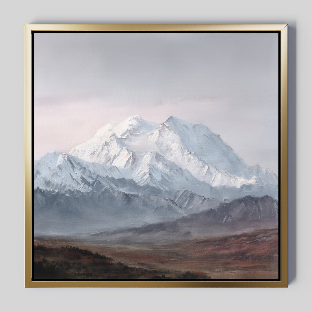 Alpine Majesty Canvas Art - Square: A framed canvas print of snow-covered peaks beneath a cloudy sky, with rocky foothills and a brown grassy plain, in a gold frame featuring a black inner edge.