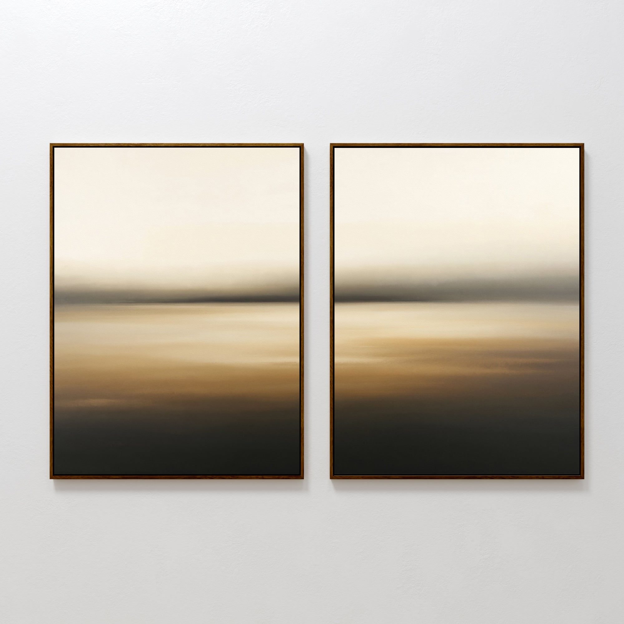 Amber Fields - Set Of 2 features framed abstract artworks with soft, blurred beige, brown, and black gradients, creating a calm and minimal landscape effect when hung side by side on a white wall.