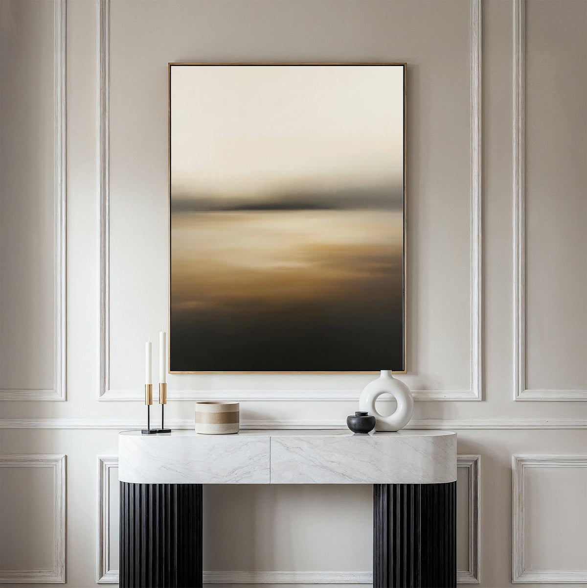 A minimalist console table with decorative items stands against an elegantly molded wall, topped by the Amber Fields Canvas Art - Vertical in warm amber tones.