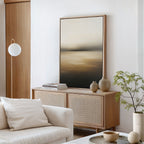 A minimalist living room featuring the Amber Fields Canvas Art - Vertical, a light wood sideboard, neutral vases, stacked books, a white sofa with cushions, amber accents, a small plant, and a round white lamp by the wooden door.