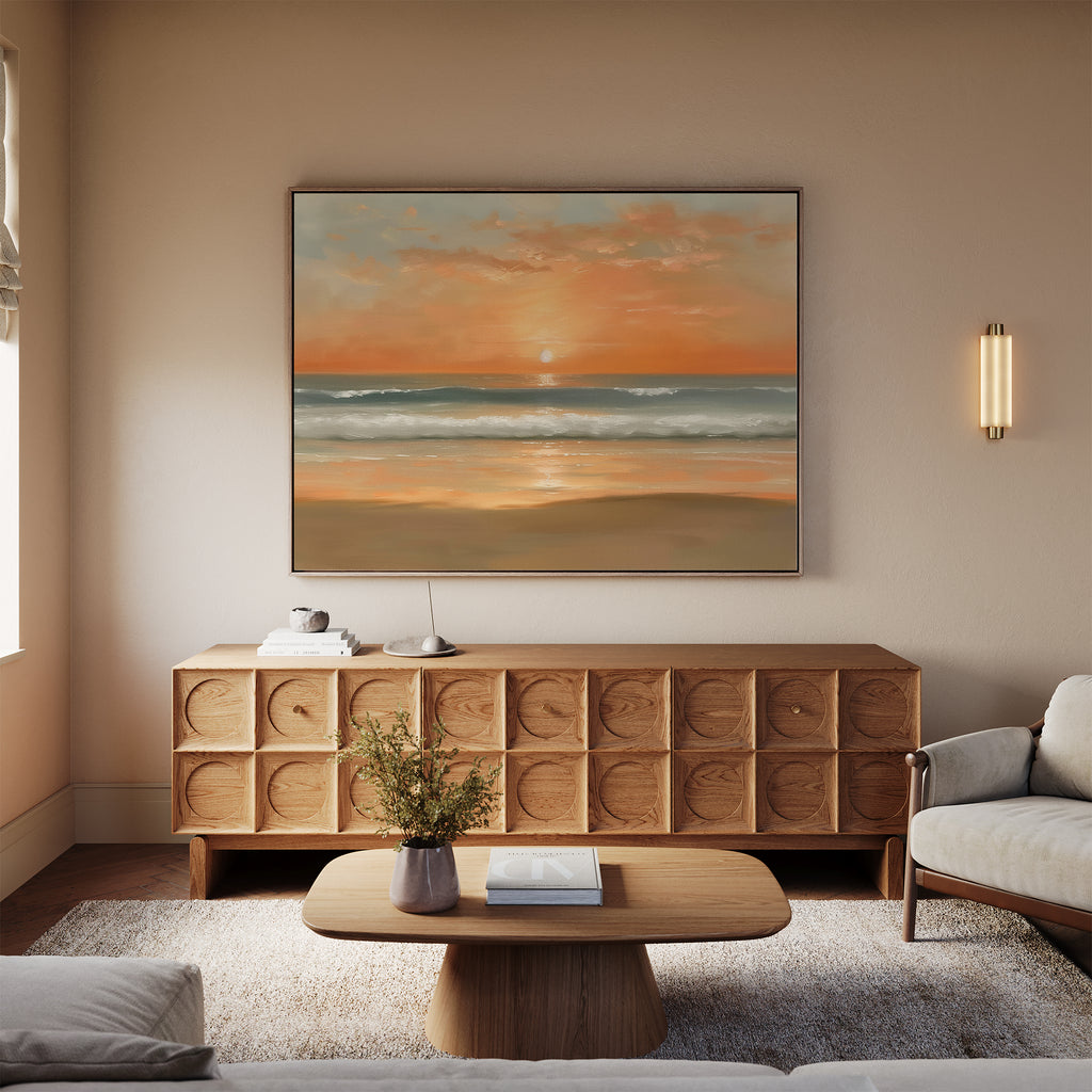 A modern living room with a beige sofa, light wood coffee table, and a sideboard displaying the Amber Horizon Canvas Art - Horizontal. Soft lighting and a flower vase complete the calm, inviting Nordic Park-inspired atmosphere.