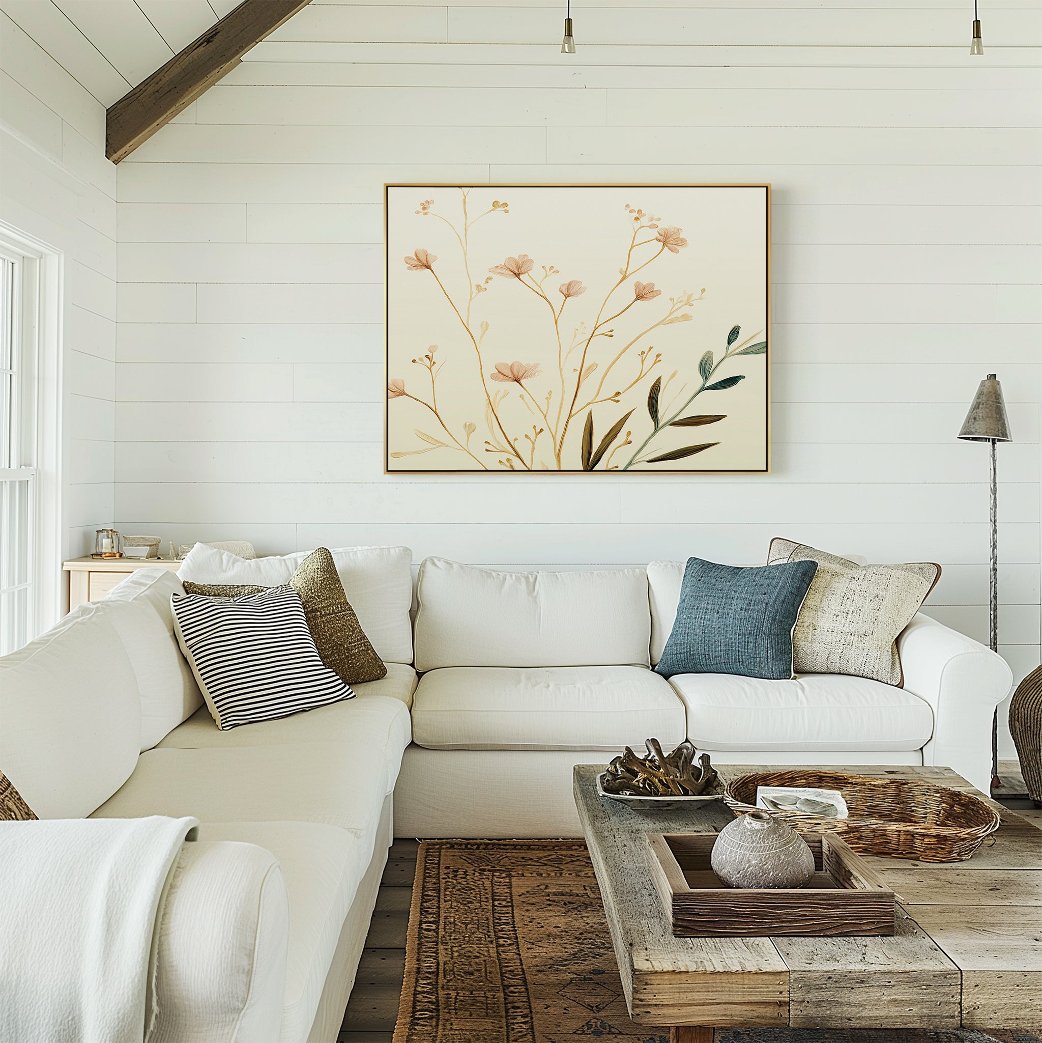 A cozy living room features a white sectional sofa, assorted throw pillows, a rustic wooden coffee table, and the Autumn Botanicals Canvas Art - Horizontal on a white shiplap wall. Natural light fills the space for a warm, inviting feel.