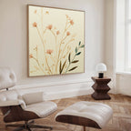 A modern living room featuring a white leather lounge chair and ottoman, a dark wood side table with lamp, and the Autumn Botanicals Canvas Art - Square brings Nordic Park-inspired charm with delicate floral accents.