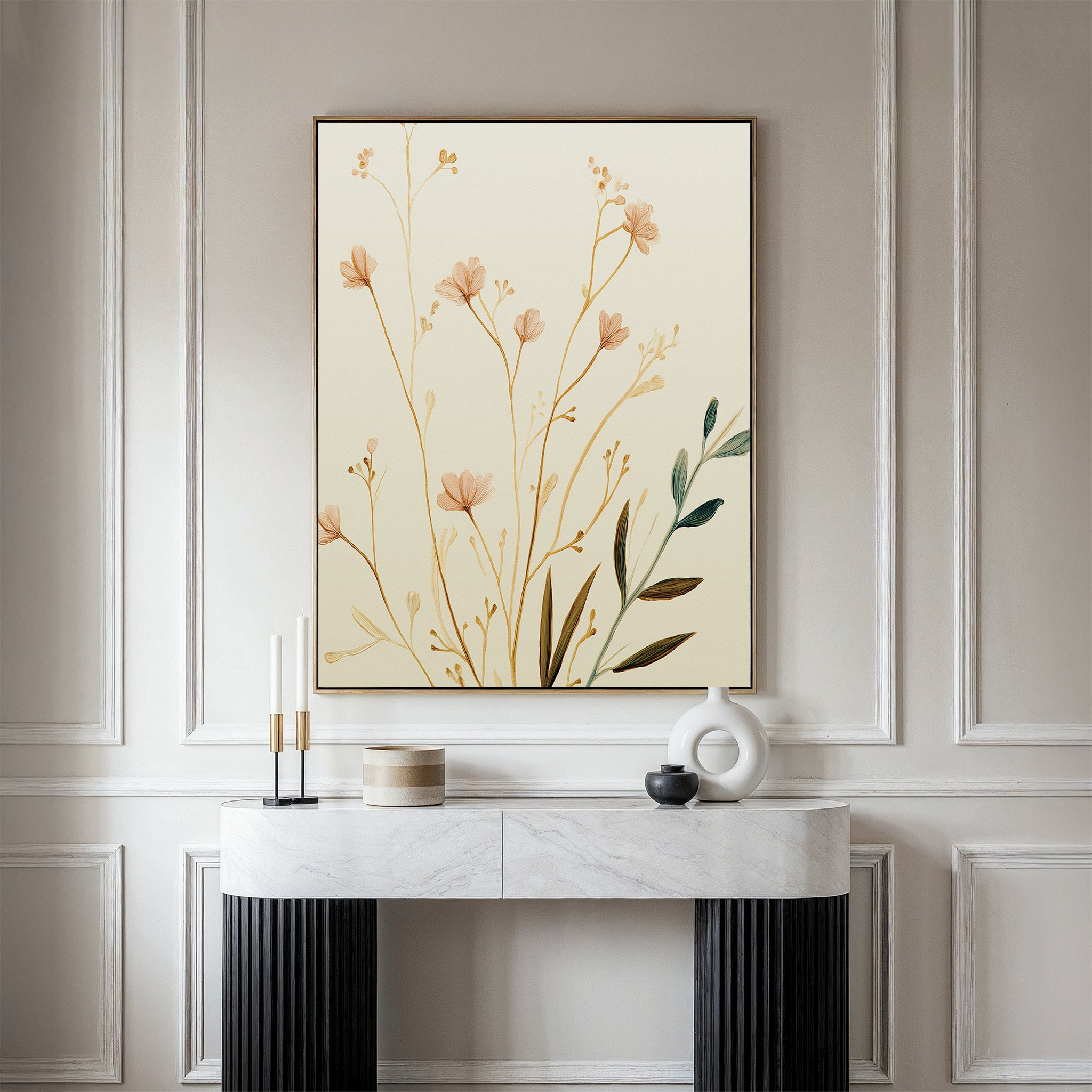 A minimalist entryway features a marble console table with black legs, decorative objects, and the Autumn Botanicals Canvas Art - Vertical, showcasing delicate beige flowers and green leaves for an elegant seasonal touch.