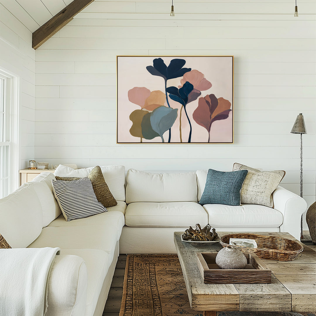 A cozy living room with a white sectional, assorted cushions, a rustic wood coffee table, and the Autumn Garden Canvas Art - Horizontal on a white shiplap wall. Natural light streams in from a left window.