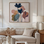 A modern living room with a beige sofa, neutral pillows, and a ceramic lamp on the side table features the Autumn Garden Canvas Art - Square on the wall. A vase of dried flowers adds warmth atop the coffee table.
