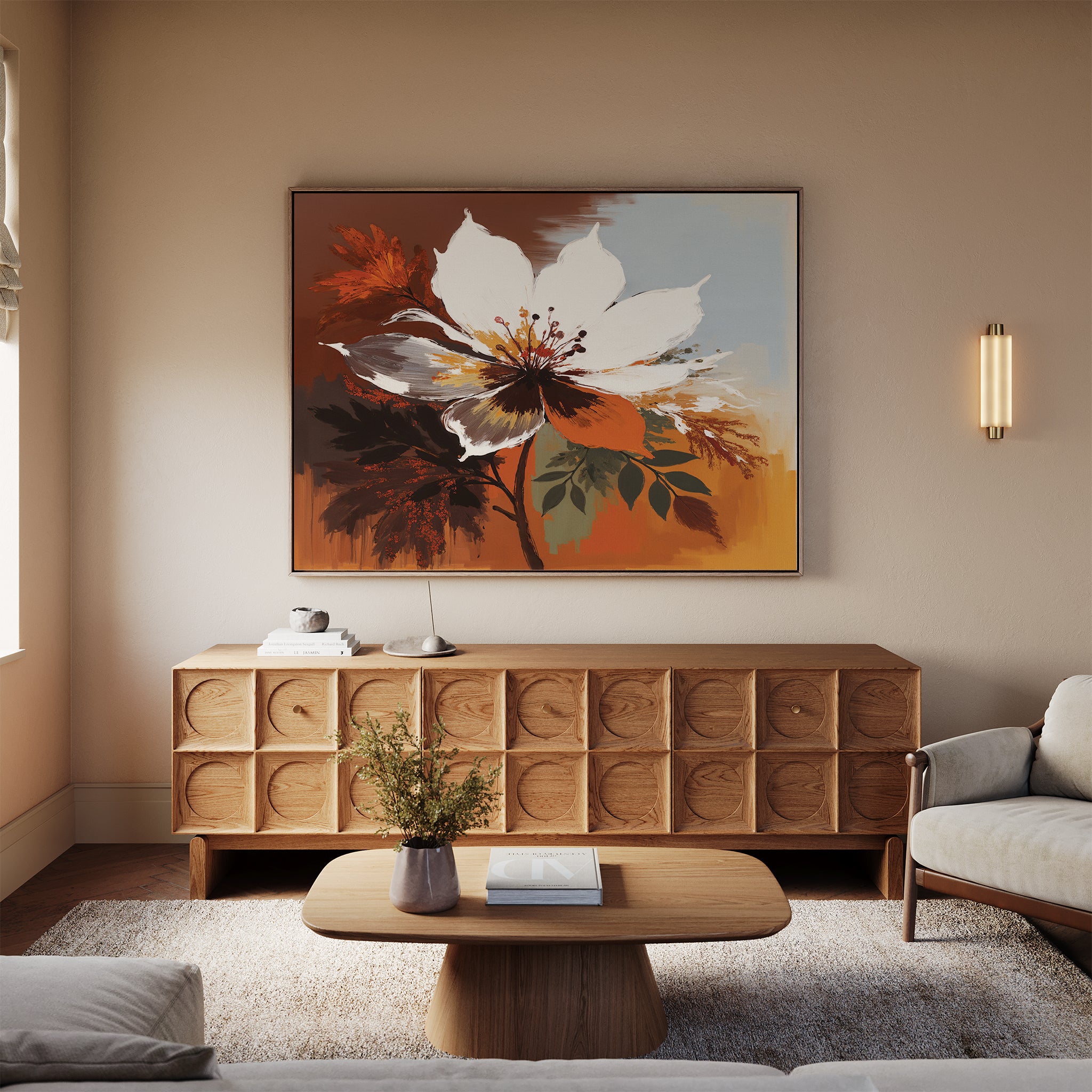 A cozy living room with a beige sofa, wooden coffee table, and sideboard featuring the Autumn Radiance Canvas Art - Horizontal in warm tones. A small plant, books, and soft lighting complete the serene, modern decor.