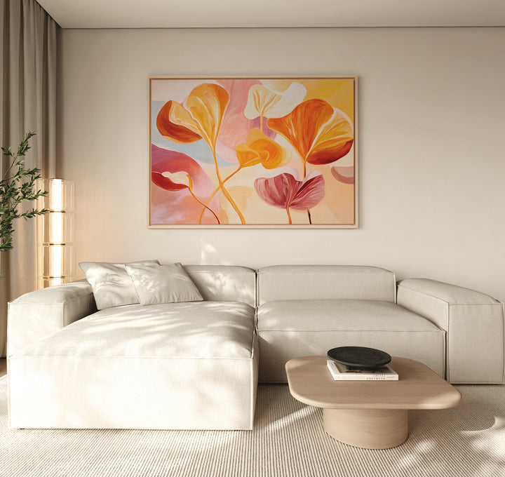 A modern living room with a light beige sectional sofa, wooden coffee table topped with a black bowl, and the Autumn Reverie Canvas Art - Horizontal, a large colorful abstract floral painting, displayed above the sofa and filled with natural light.
