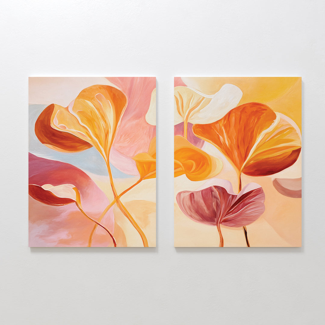 Autumn Reverie - Set of 2: Abstract autumn canvas prints with large, flowing leaves in warm orange, pink, and yellow on pastel backgrounds—ideal botanical wall art for floral home decor. Displayed side by side on a white wall.
