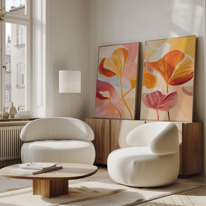 A bright, modern living room with two white curved chairs, a wooden coffee table, and a sideboard displaying the Autumn Reverie - Set of 2 botanical wall art in warm tones near a large window.