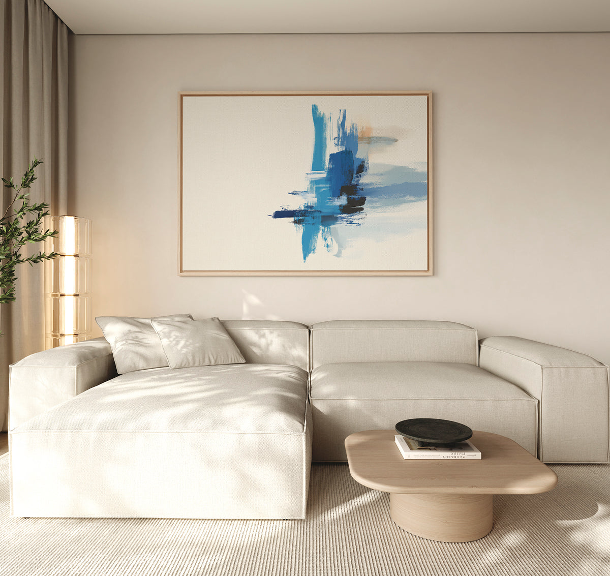 Minimalist living room with a light beige sectional sofa, a low wooden coffee table, a black bowl, a tall plant, and the Azure Convergence Canvas Art - Horizontal featuring blue tones displayed above the sofa.