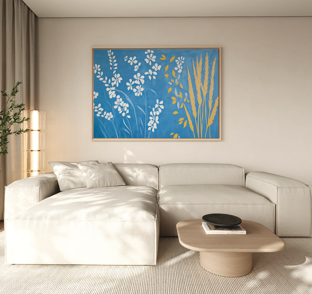 A modern living room with a light beige sectional sofa, a light wood coffee table, and the Azure Meadow Canvas Art - Horizontal as botanical wall art. Minimal decor pairs with natural light from tall windows draped in beige curtains.
