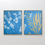 The Azure Meadow - Set of 2 adds charm to the wall: one print features white wildflowers on blue, while the other displays yellow wheat stalks and leaves on an azure background.