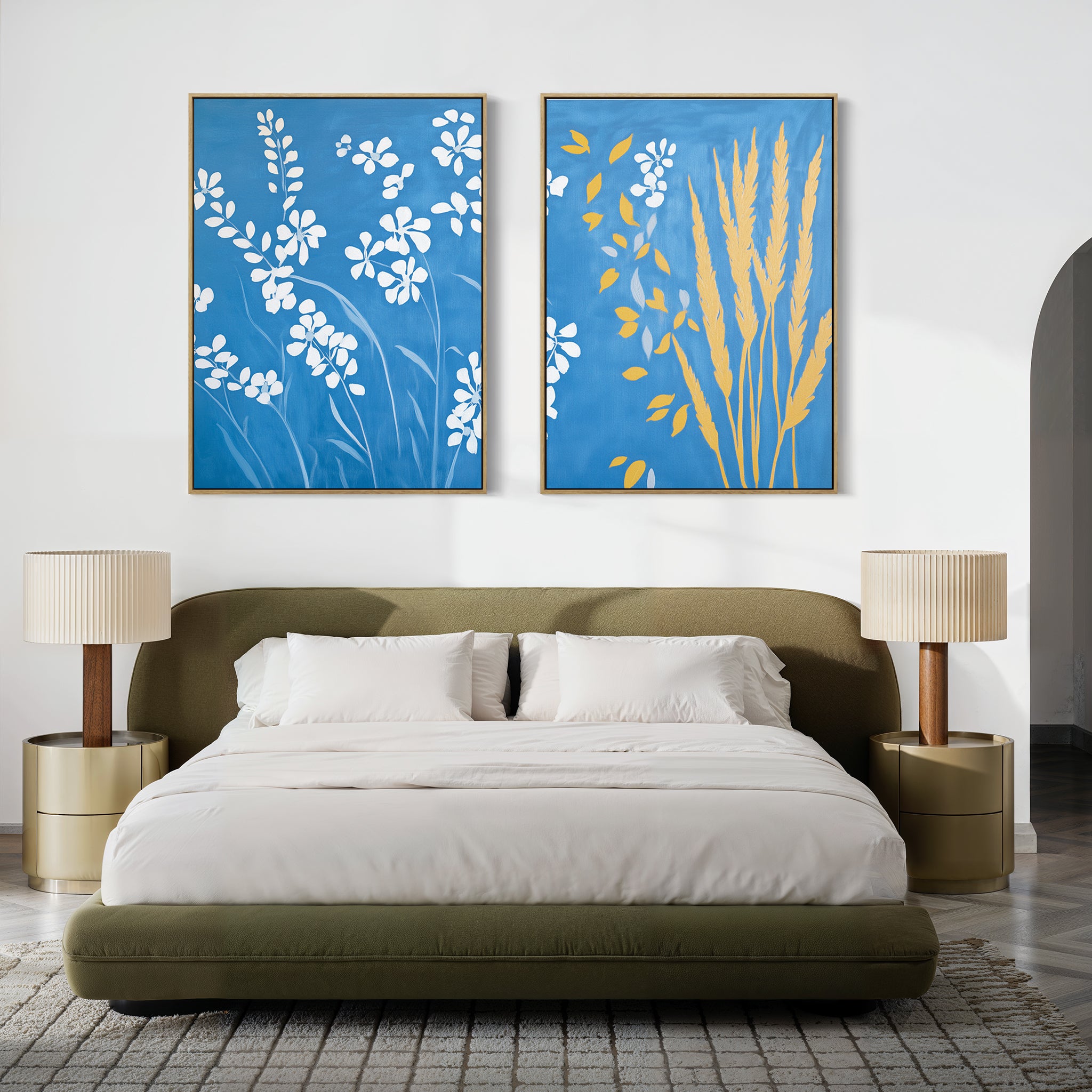 A modern bedroom features a green upholstered bed, beige bedding, two beige nightstands with matching lamps, and the Azure Meadow - Set of 2 canvas prints of white wildflowers above the bed for a serene Nordic Park-inspired touch.
