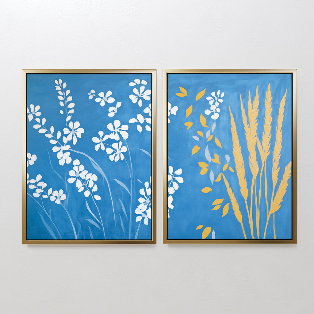 The Azure Meadow - Set of 2 features framed botanical prints: one with white wildflowers on blue, the other with yellow wheat and white blooms. Both evoke the calm beauty of a Nordic park on your wall.