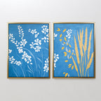 The Azure Meadow - Set of 2 features framed botanical prints: one with white wildflowers on blue, the other with yellow wheat and white blooms. Both evoke the calm beauty of a Nordic park on your wall.