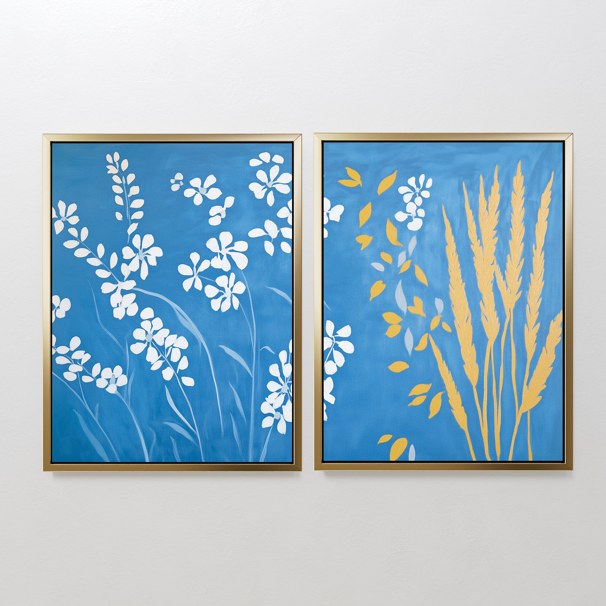 The Azure Meadow - Set of 2 features framed botanical prints: one with white wildflowers on blue, the other with yellow wheat and white blooms. Both evoke the calm beauty of a Nordic park on your wall.
