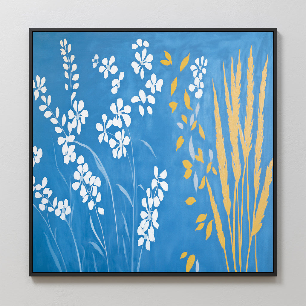 The Azure Meadow Canvas Art - Square features framed botanical wall art with white floral silhouettes on the left and yellow wheat stalks with leaves on the right, set against a rich blue background.