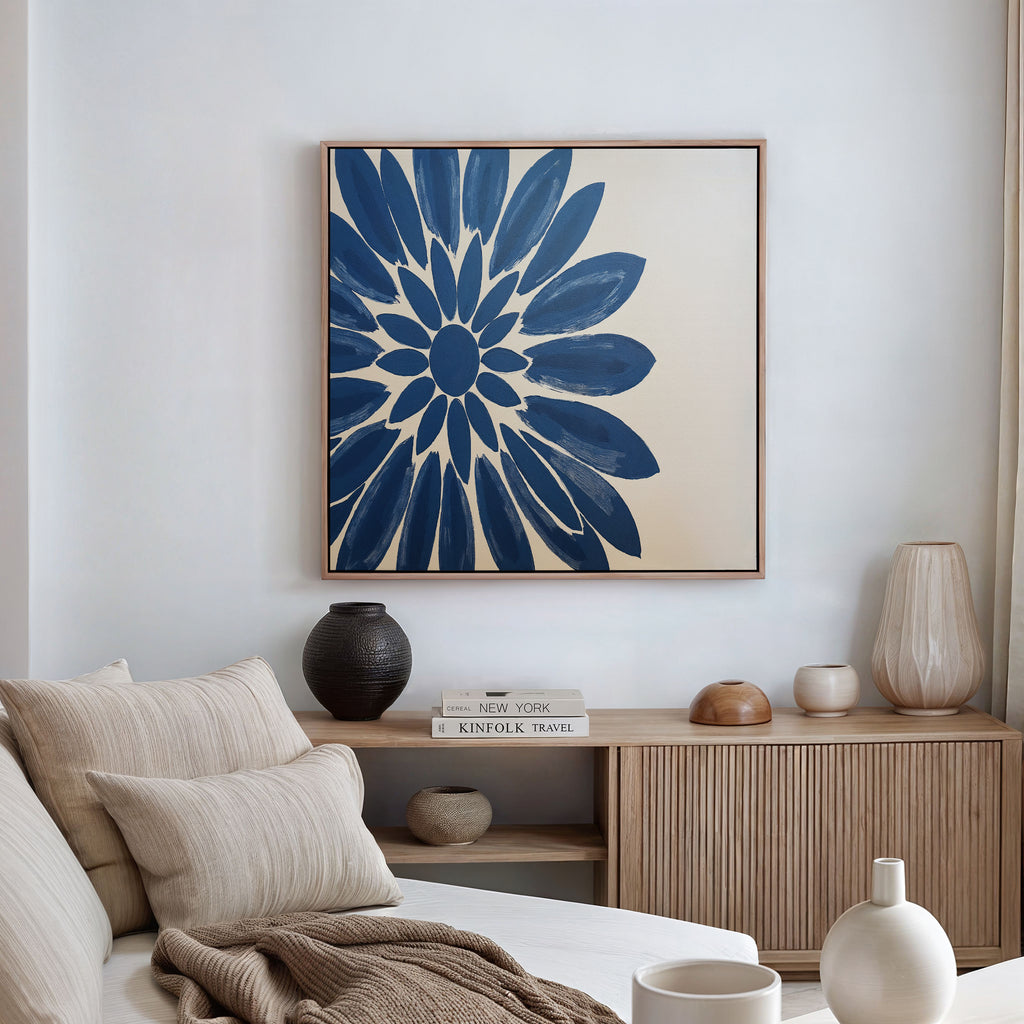 A modern living room with a beige sofa, neutral cushions, a wooden sideboard, ceramic vases, and the Azure Radiance Canvas Art - Square—a large floral blue artwork with overlapping petals—hanging above for stylish modern decor.