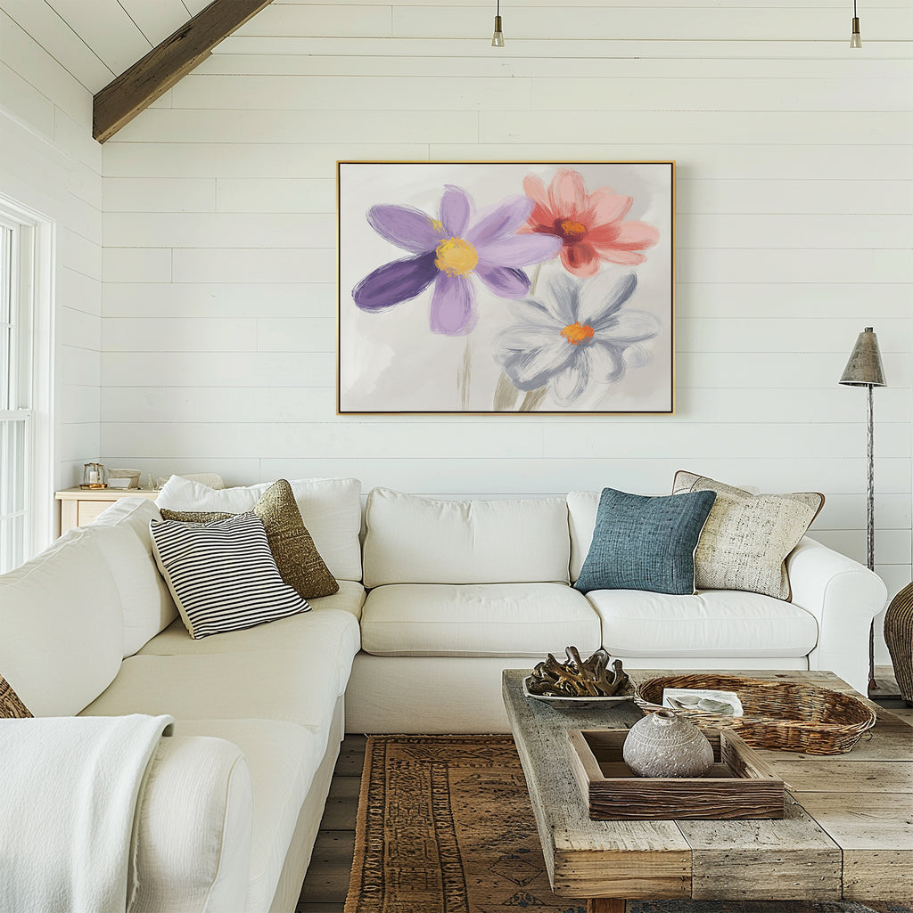 A bright, cozy living room with white shiplap walls, a large L-shaped white sofa, rustic wooden coffee table, and the "Blooming Harmony Canvas Art - Horizontal" featuring purple, pink, and white flowers on the wall.