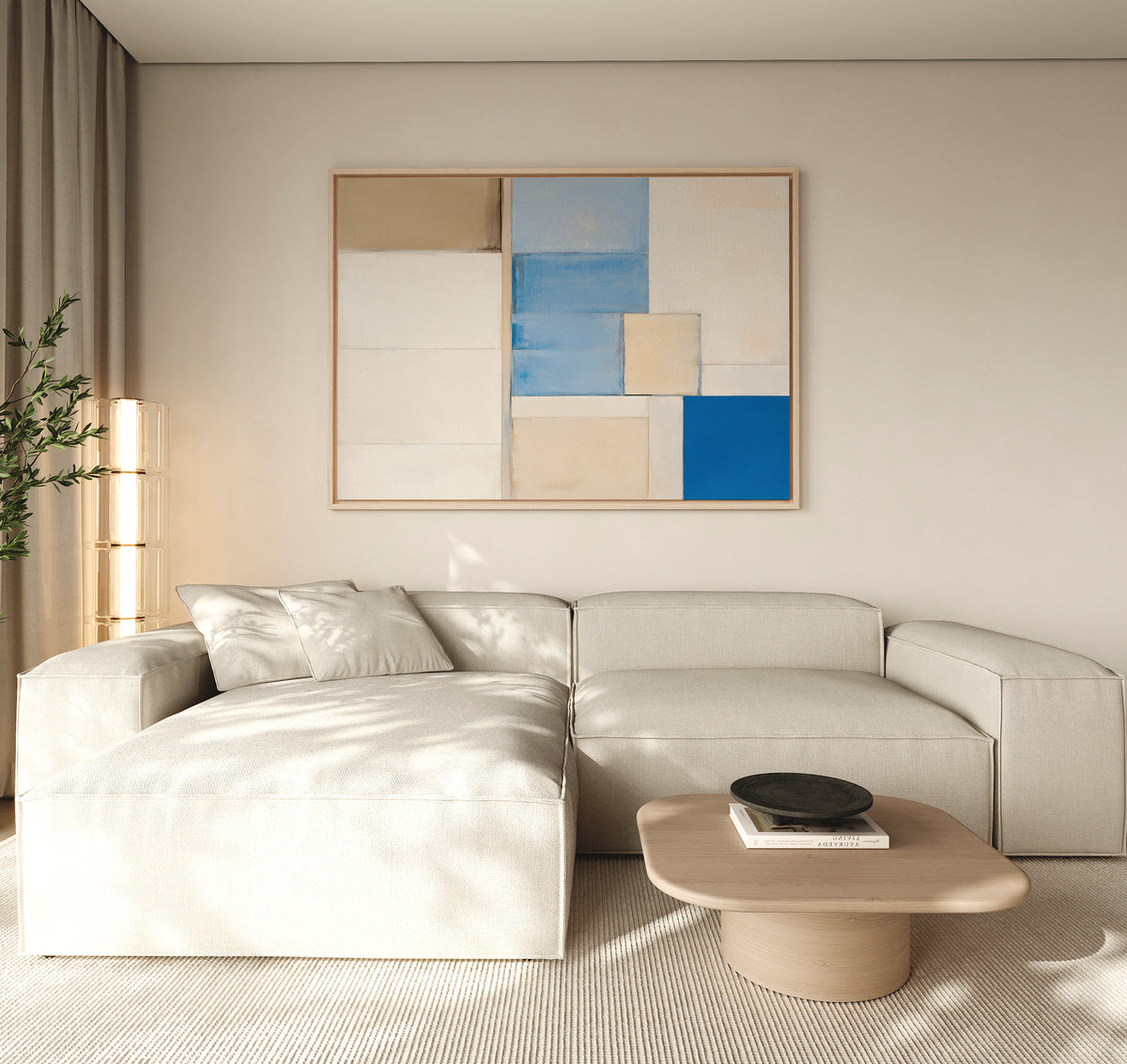 A modern living room with a light beige sectional sofa, a low wooden coffee table, and the Blue Tiles Composition Canvas Art - Horizontal in white, beige, and blue tones above the sofa. Light streams in from the left, highlighting the stylish decor.