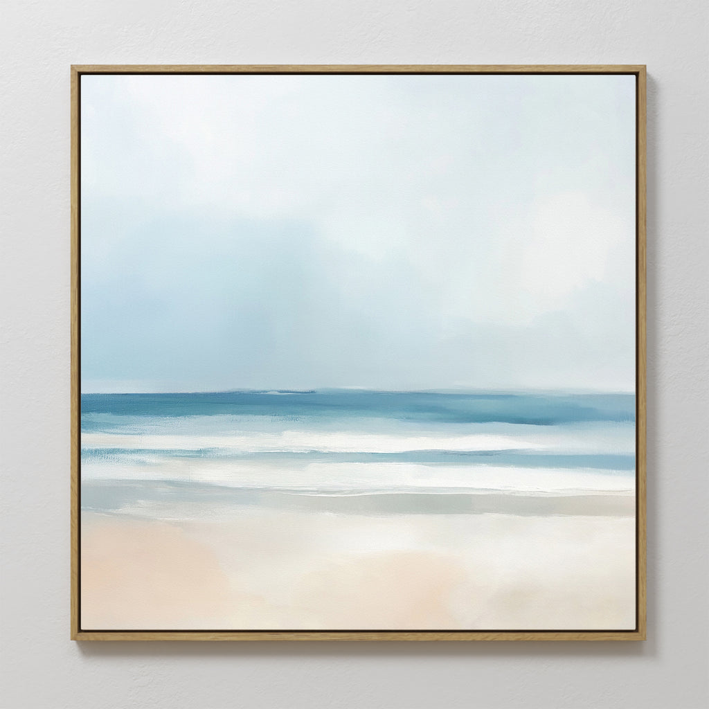 The Blurred Beach Scene Canvas Art - Square features a minimalist, impressionistic coastal print with soft blue waves, a hazy sky, and pale sand—ideal as tranquil wall art for any space.
