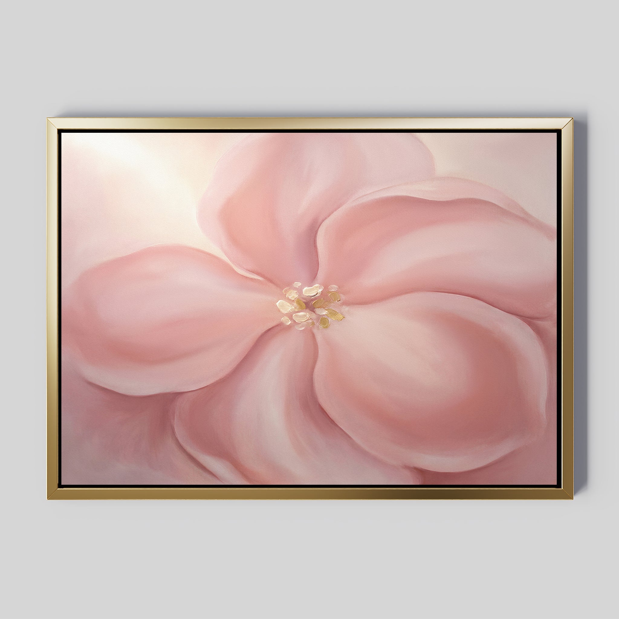 The Blushing Magnolia Canvas Art - Horizontal features a large, soft pink magnolia with delicate petals and a light yellow center on a pale background. Its gold frame with a black inner border adds an elegant touch to any space.