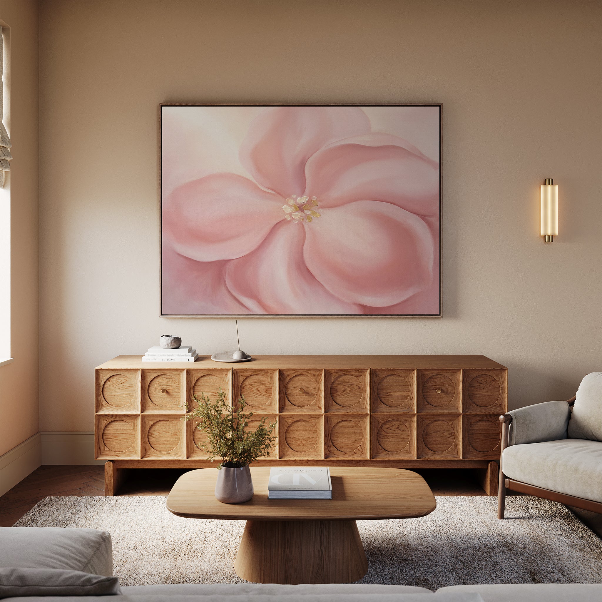A cozy living room features a modern wooden coffee table, textured sideboard, and the Blushing Magnolia Canvas Art - Horizontal above a light sofa, with neutral walls and a flower vase on the table for soft romantic charm.