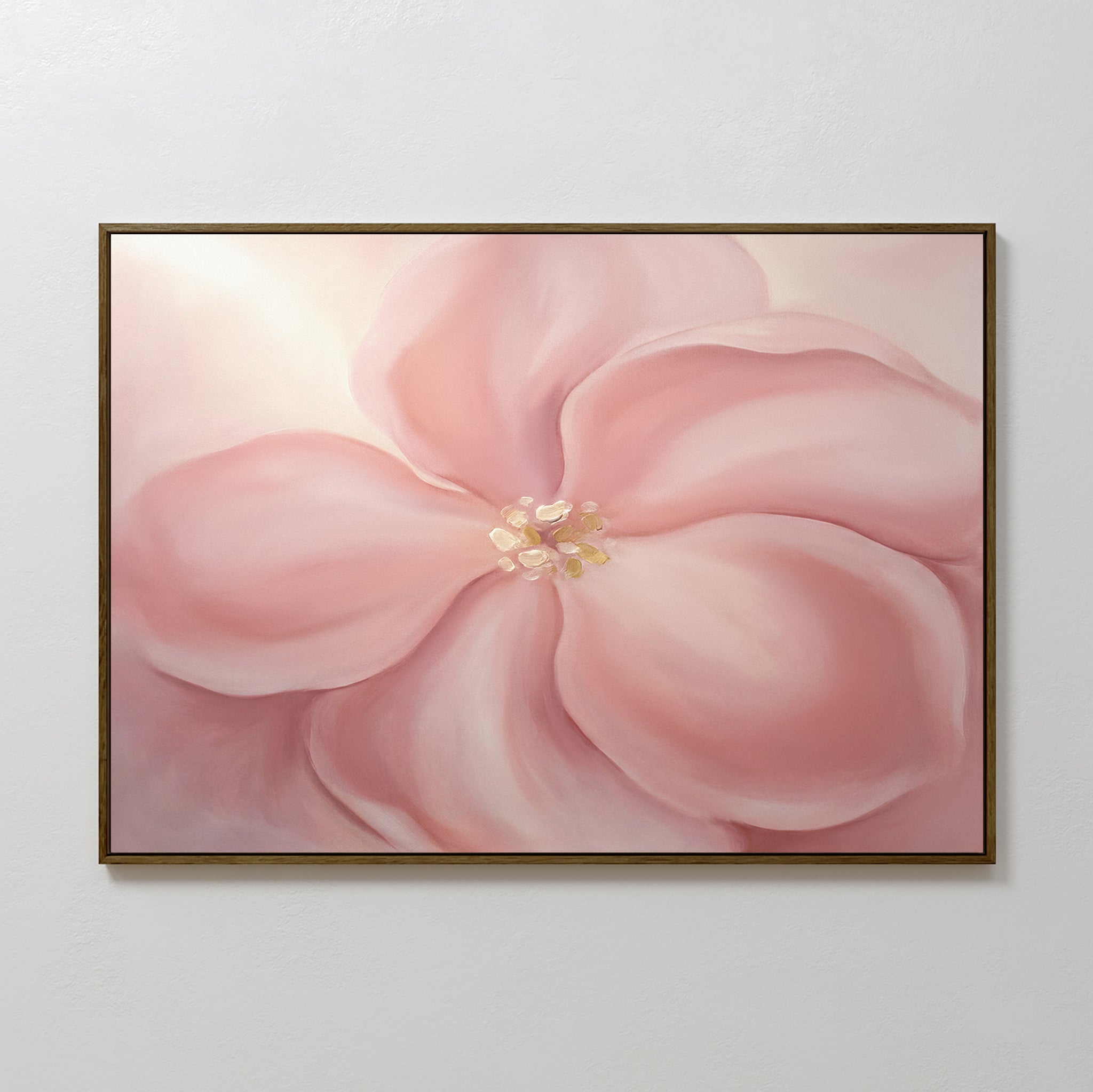 The Blushing Magnolia Canvas Art - Horizontal showcases a large, soft pink magnolia with flowing petals and a creamy center, beautifully framed and displayed against a plain white wall.