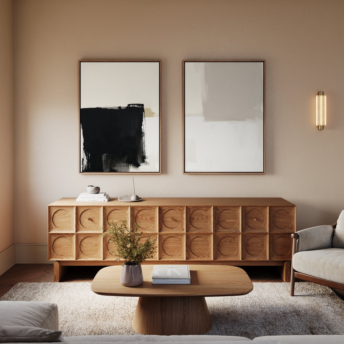 A modern living room with a wooden coffee table, matching sideboard, gray armchair, soft rug, minimalist wall sconce, and Bold Division - Set Of 2 contemporary prints on the wall. A small plant on the table completes this modern inspiration.