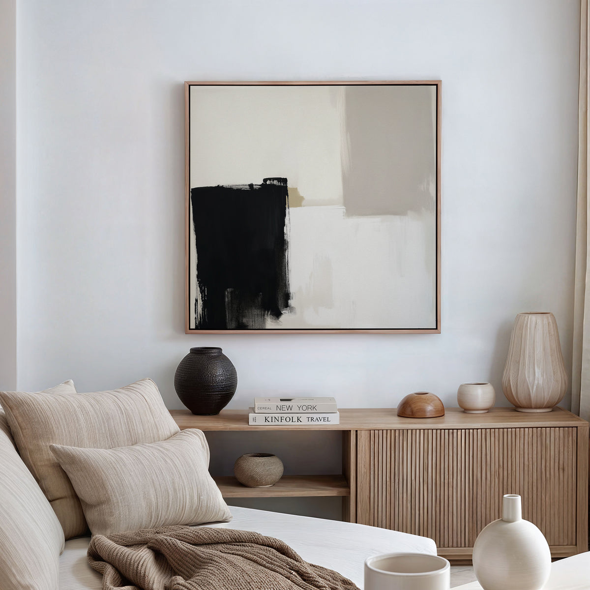 A modern living room featuring a beige couch, neutral cushions, a wooden sideboard with vases and books, and the Bold Division Canvas Art - Square inspired by Nordic Park artwork displayed on a white wall.