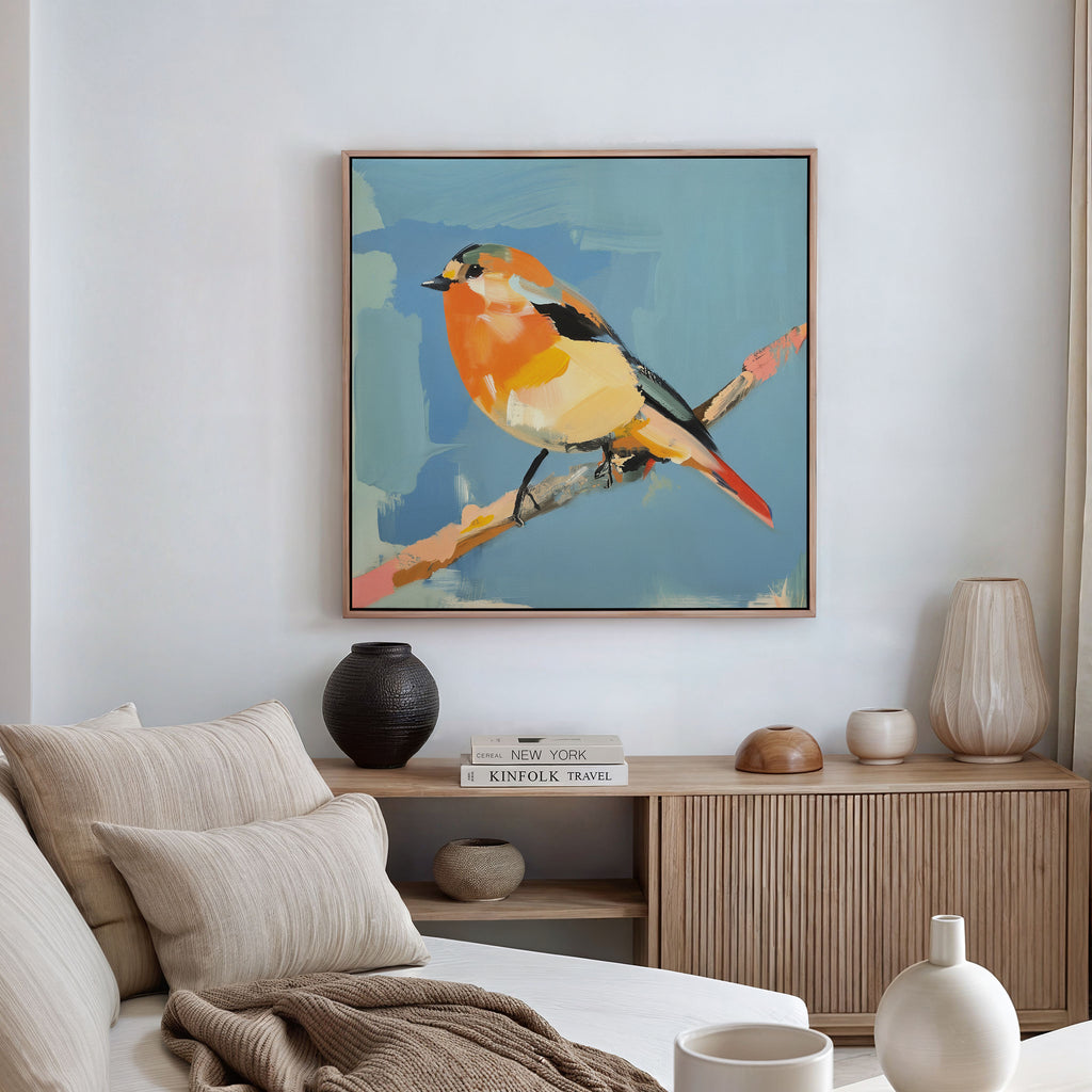 A modern living room with neutral decor features the Bright Songbird Canvas Art - Square above a wooden sideboard with vases and books, complemented by a beige sofa with cushions for an inviting touch.