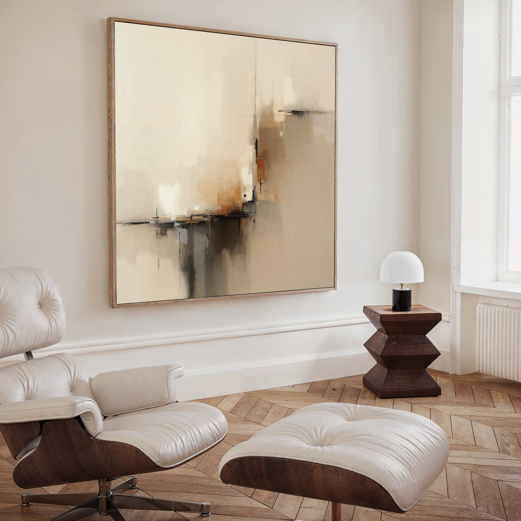 A modern, minimalist living room with a white lounge chair and ottoman, Burnt Sienna Convergence Canvas Art - Square as wall art, a geometric wooden side table, and a small white lamp on herringbone wood flooring.