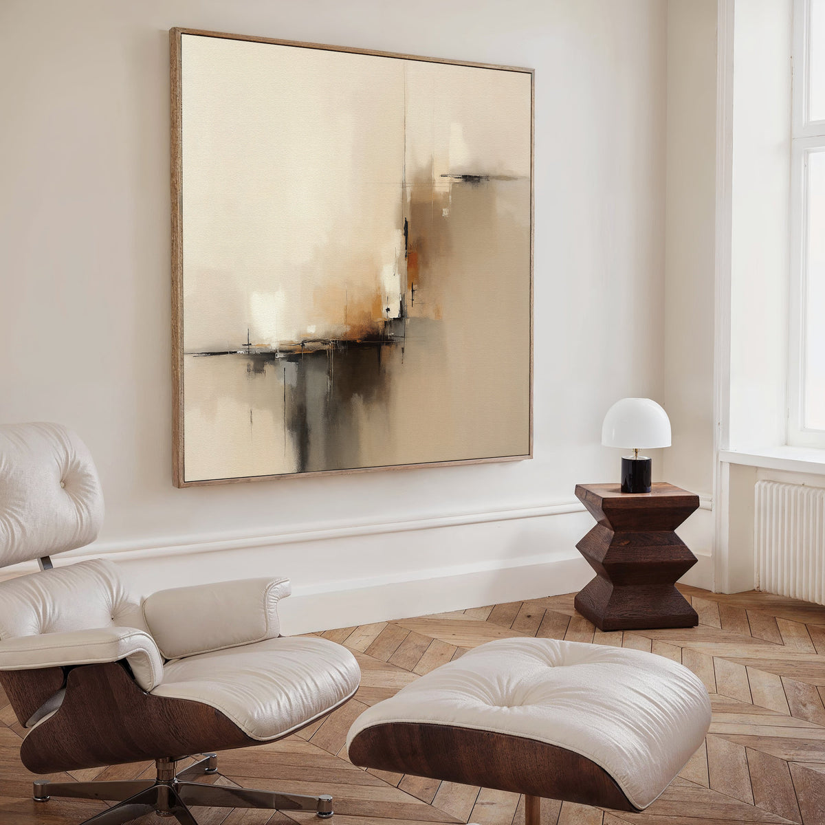 A modern, minimalist living room with a white lounge chair and ottoman, Burnt Sienna Convergence Canvas Art - Square as wall art, a geometric wooden side table, and a small white lamp on herringbone wood flooring.