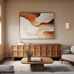 A modern living room featuring a light beige sofa, wooden coffee table, textured sideboard, and the Canyon Curves Canvas Art - Horizontal adds warmth and style, highlighted by soft natural lighting and a sleek wall-mounted light fixture.