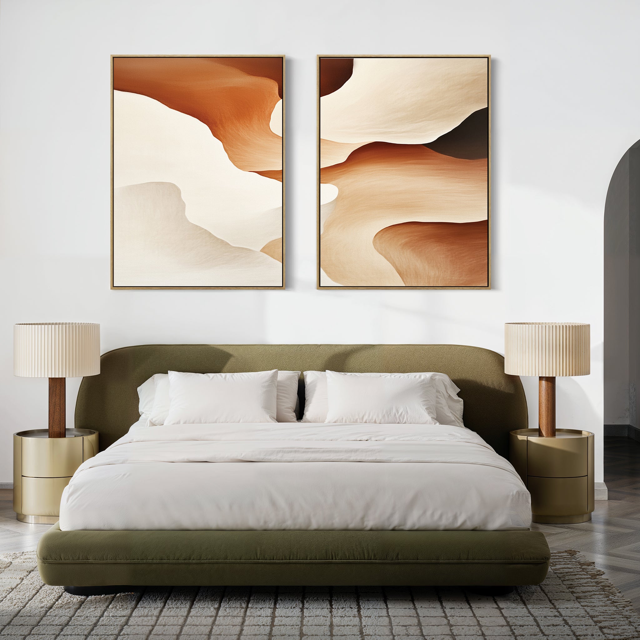 A modern bedroom with an olive green upholstered bed, white bedding, two gold round nightstands with beige lamps, and Canyon Curves - Set Of 2 wall art above the bed. A textured rug covers the floor.