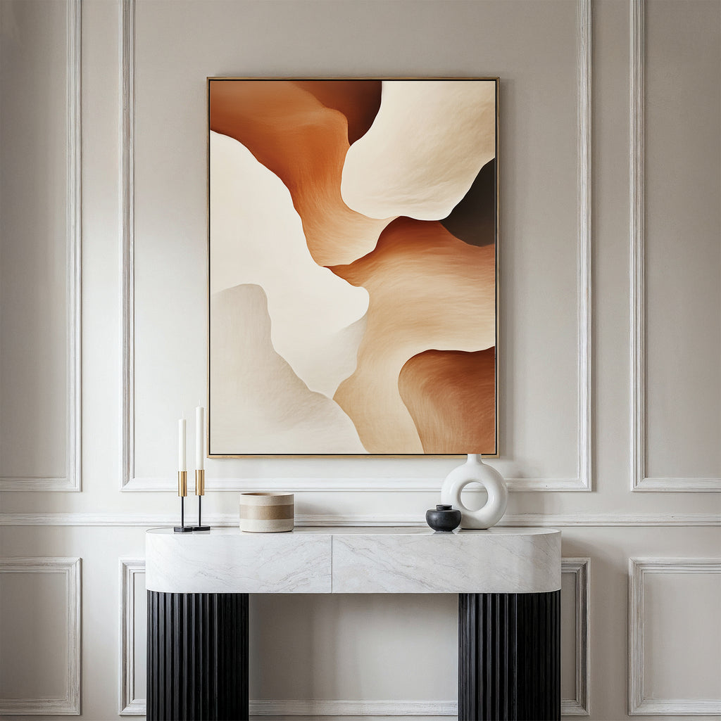 A minimalist console table with decorative objects sits against a paneled wall, topped by the Canyon Curves Canvas Art - Vertical in warm beige, brown, and cream—an ideal accent for modern living rooms.